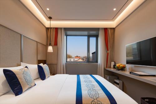 Un dormitorio con una cama grande y una ventana en Dongsi No 78 Boutique Apartment en Beijing