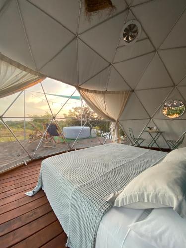 a bedroom in a tent with a bed on a deck at PRANA hOMe in San Carlos