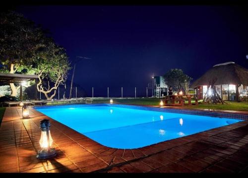 a large blue swimming pool at night at Hole in the Wall - Unit 47 in Coffee Bay
