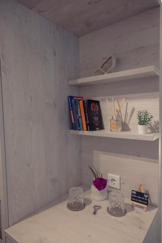 a shelf with books and flowers on a desk at C-YOU Hotel Chemnitz in Chemnitz