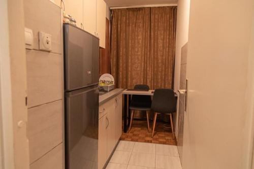 a kitchen with a refrigerator and a table with a dining room at Apartman TWO 
