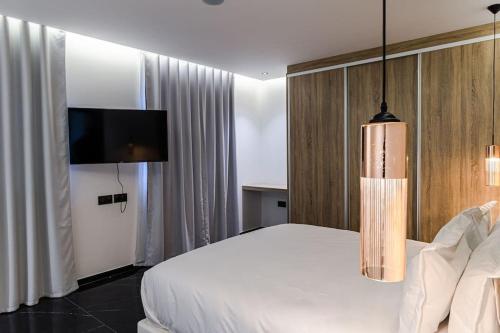 um quarto com uma cama branca e uma televisão de ecrã plano em Marrakech villa avec piscine privée 4 chambres 4 salles de bains em Marrakech