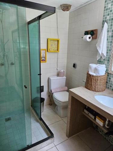ein Bad mit einer Dusche, einem WC und einem Waschbecken in der Unterkunft Apart Coração de Búzios in Búzios