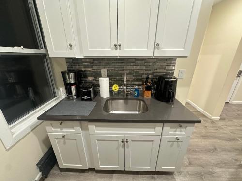 a kitchen with white cabinets and a sink at Upscale Super LUX Private 2br Near NYC in New Rochelle