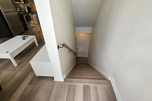 a hallway with a staircase with a white stair case at Modern 2BR Townhouse w Patio & Free Parking Family & Work Stays in Toronto