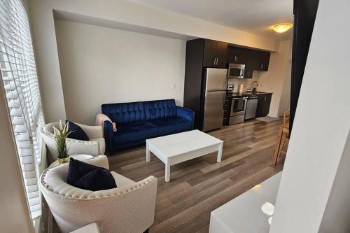a living room with a blue couch and a table at Modern 2BR Townhouse w Patio & Free Parking Family & Work Stays in Toronto