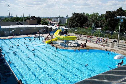 a large swimming pool with a slide in the middle at Modern 2BR Townhouse w Patio & Free Parking Family & Work Stays in Toronto