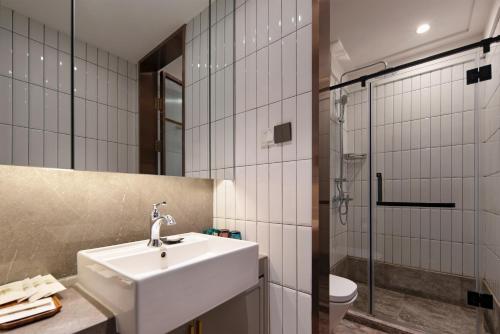 a bathroom with a sink and a toilet and a shower at Dongsi No 78 Boutique Apartment in Beijing