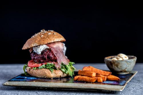 a sandwich on a plate with a side of fries at Sporthotel Zoll in Vipiteno