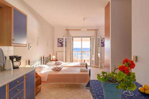 een slaapkamer met een bed en een keuken met een raam bij Beachfront House Tolis - Pelekas Beach in Pelekas