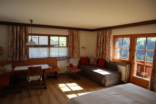 - un salon avec un lit, un canapé et une table dans l'établissement Haus Moosbrunn, à Alpbach