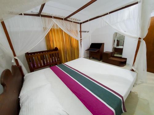 1 dormitorio con 1 cama blanca grande y escritorio en Thotupola Villa - Mirissa, en Mirissa