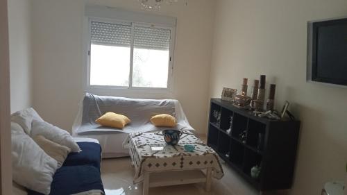 un soggiorno con divano e tavolo di Appartement a skhirat a Skhirat