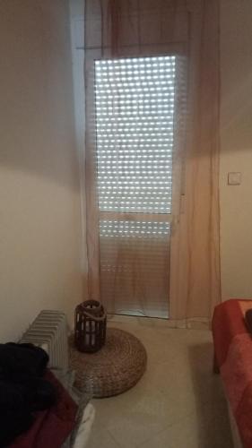 una camera da letto con finestra e cesto sul pavimento di Appartement a skhirat a Skhirat