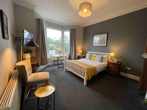 um quarto com uma cama, uma cadeira e uma mesa em Serviced Apartment- 1 Bed-Next To Train Station em Sleightholme