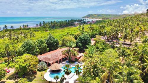 uma vista aérea de um resort com palmeiras e o oceano em Eco Pousada Paraíso dos Coqueirais em Japaratinga