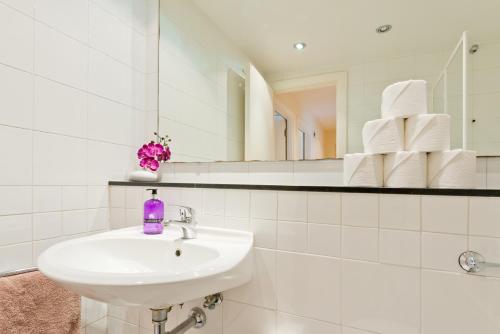Baño blanco con lavabo y espejo en Dublin City Retreat, en Dublín
