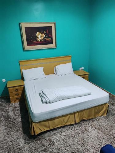 a bed in a room with a blue wall at منتجع الريحانه فله رقم 1 in Taif