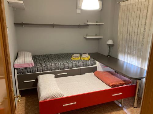 een kleine kamer met 2 bedden en een bureau bij Apartamento Sanchiz in Monóvar