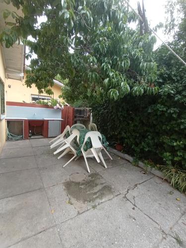 zwei Gartenstühle sitzen auf einem Bürgersteig in der Unterkunft Casasodali in Villa Gesell