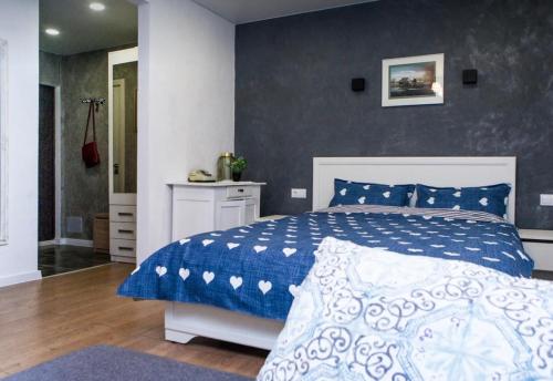 1 dormitorio con 1 cama con edredón azul y blanco en VIP apart 746, en Tiflis