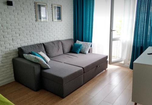 un sofá en una sala de estar con cortinas azules en VIP apart 746, en Tiflis