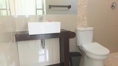 Łazienka z białą toaletą i umywalką w obiekcie WHITE SANDS RESORT w Gili Trawangan