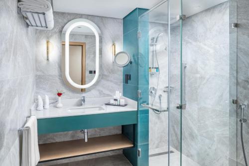 a bathroom with a sink and a shower at Taiba Suites Madinah in Al Madinah