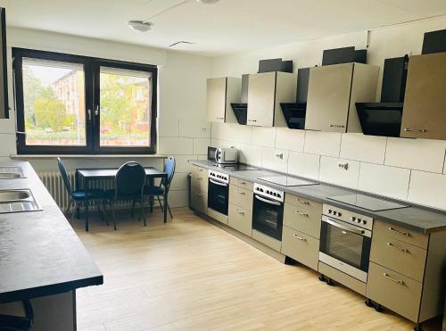 een keuken met een tafel en stoelen en een aanrecht bij Pension Alex in Bielefeld