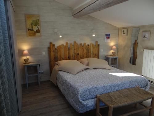 ゴルドにあるMas Val-Chênaie Gordesのベッドルーム1室(大型ベッド1台、木製ヘッドボード付)