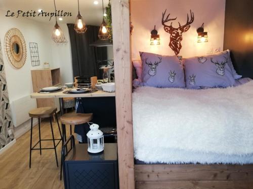 レ・ゾルにあるLe Petit Aupillon - L'Aupillon des Forêts - 2 studios cocooning aux Orresのベッド1台、テーブル、カウンターが備わる客室です。