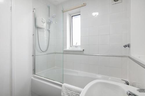 een witte badkamer met een douche en een wastafel bij CONTRACTORS, Central MK, Free off street Parking, close to amenities, Managed by Chique Properties Ltd in Milton Keynes