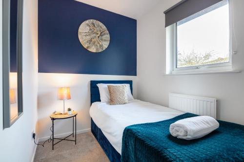 a bedroom with a bed and a clock on the wall at CONTRACTORS, Central MK, Free off street Parking, close to amenities, Managed by Chique Properties Ltd in Milton Keynes