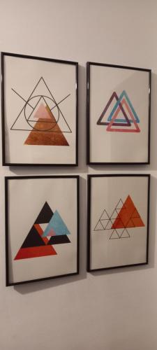 vier gerahmte Zeichnungen von Pyramiden an einer Wand in der Unterkunft El capricho de Susana in Santillana del Mar