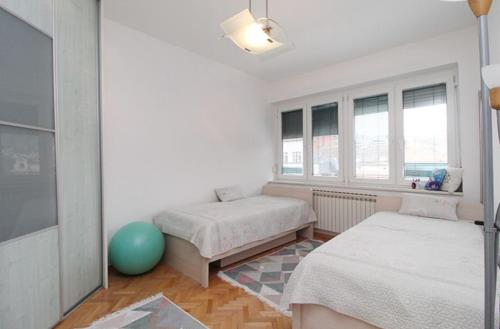 een slaapkamer met 2 bedden en een blauwe bal op de vloer bij Latin Apartment in Sarajevo