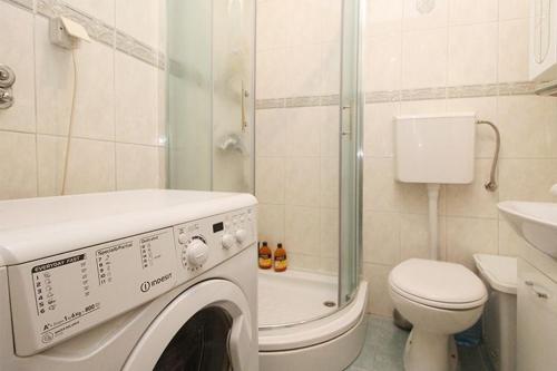 een wasmachine in een badkamer met een toilet bij Latin Apartment in Sarajevo