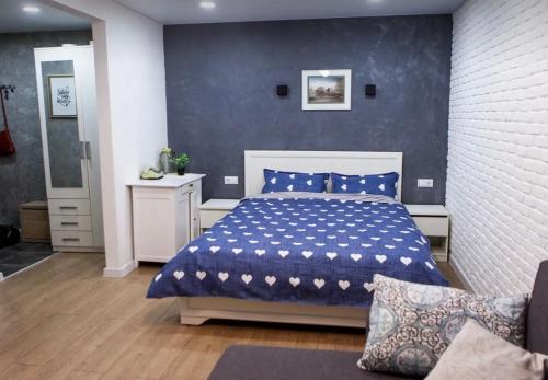 a bedroom with a bed and a blue wall at VIP apart 748 in Tbilisi City