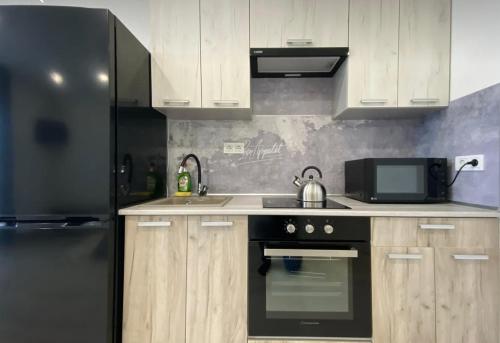 a kitchen with a black stove and a refrigerator at VIP apart 748 in Tbilisi City