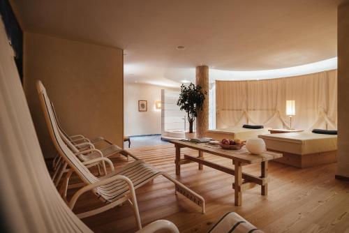 a living room with a table and chairs and a bed at Residence Villa Trieste in Corvara in Badia