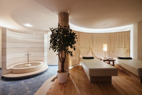 a bathroom with a bath tub and a tree in it at Residence Villa Trieste in Corvara in Badia