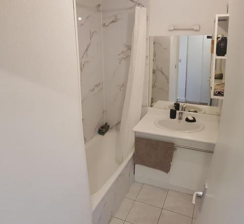 a white bathroom with a sink and a shower at Résidence avec Parking et piscine - Proche airport in Blagnac