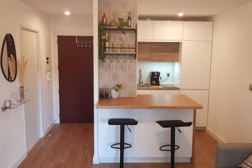 a kitchen with a counter and stools in a room at Résidence avec Parking et piscine - Proche airport in Blagnac