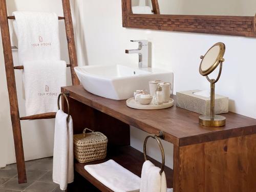 a bathroom with a sink and a mirror and towels at La Tour d'Eole in Dakhla