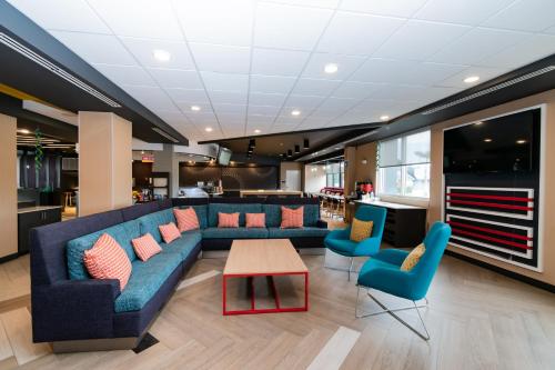 a lobby with a blue couch and blue chairs at Tru By Hilton Florida City, Fl in Florida City