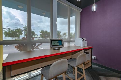 a room with a desk with two chairs and a computer at Tru By Hilton Florida City, Fl in Florida City