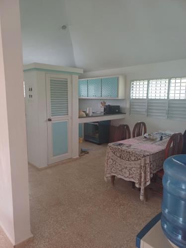 a dining room with a table and a kitchen at Mangobich in Punta Balandra