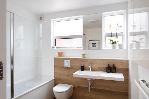 a white bathroom with a sink and a toilet at SPACIOUS Apartment in London