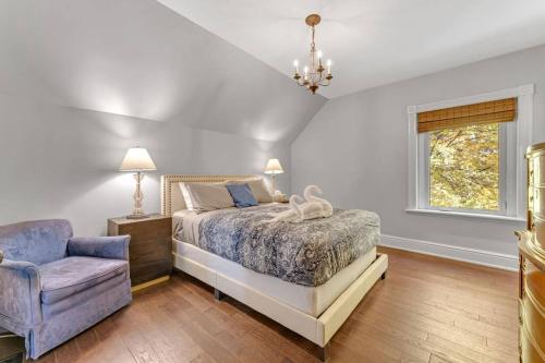 1 dormitorio con 1 cama y 1 silla azul en Hidden Oasis: Pool, Hot Tubs, & Starry Fire Pits, 