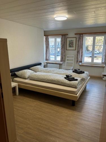 ein Schlafzimmer mit einem Bett in einem Zimmer mit Fenstern in der Unterkunft Hotel Adler Garni in Bauma