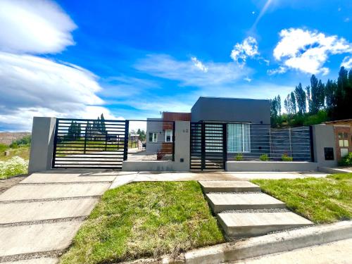 uma grande casa moderna com um céu azul em Casa del Alto, a estrenar, 3 dormitorios, 2 baños em Esquel